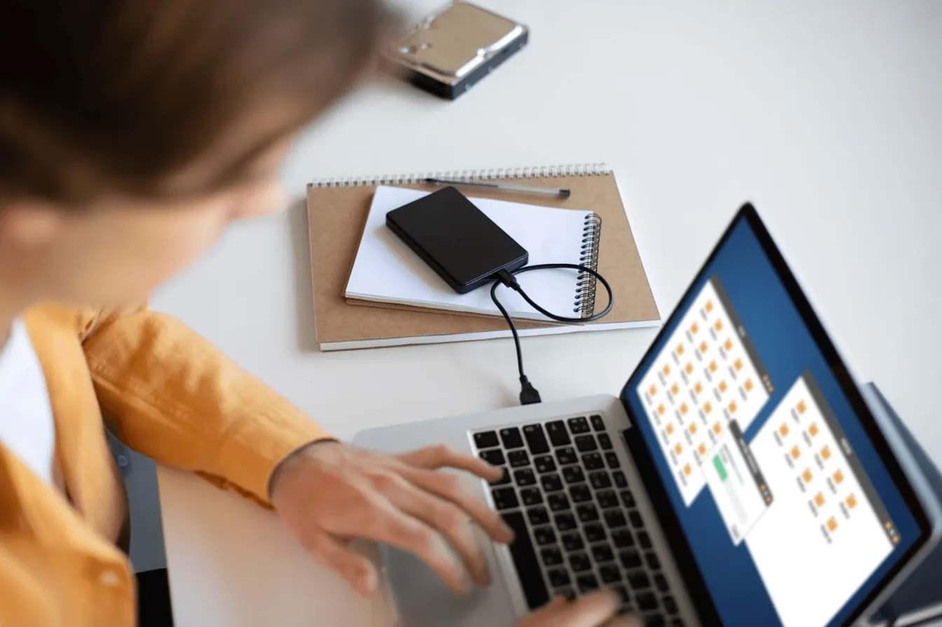 a person working on a laptop and transferring files