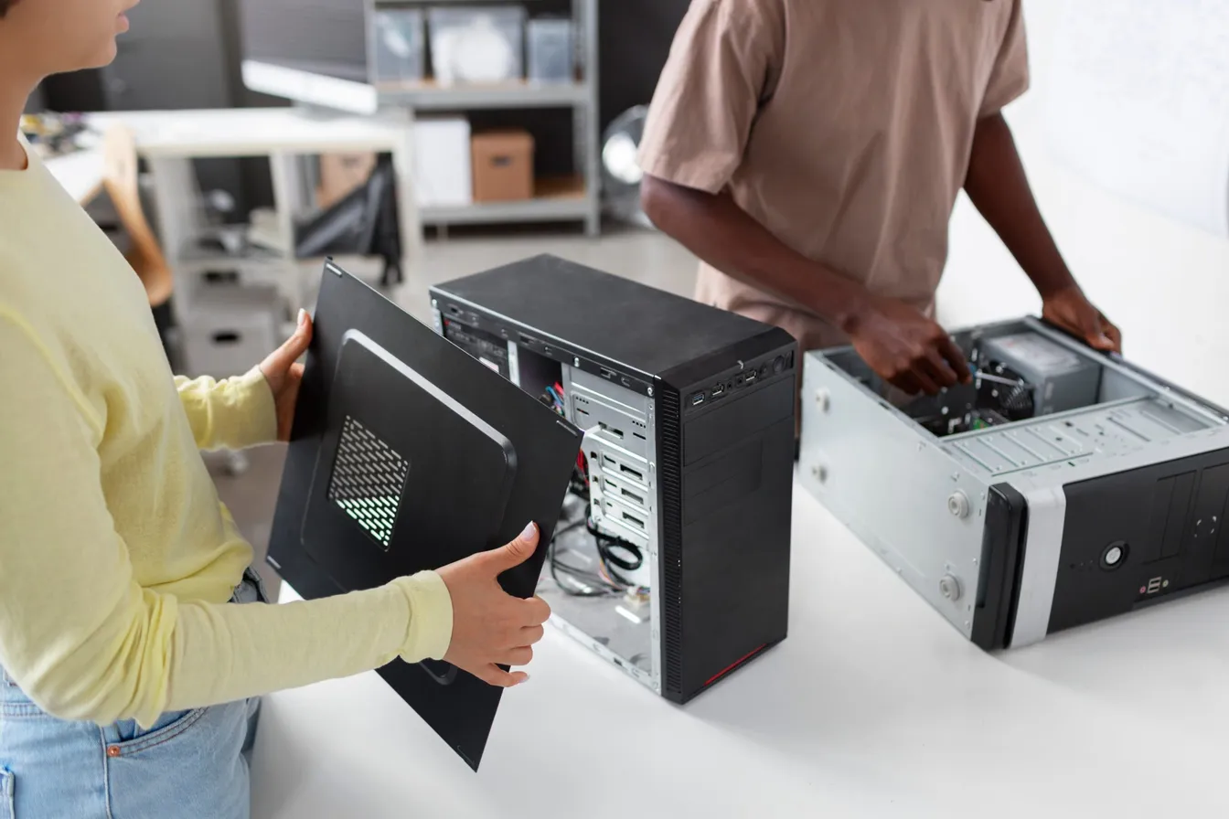 two people disassembling computer devices