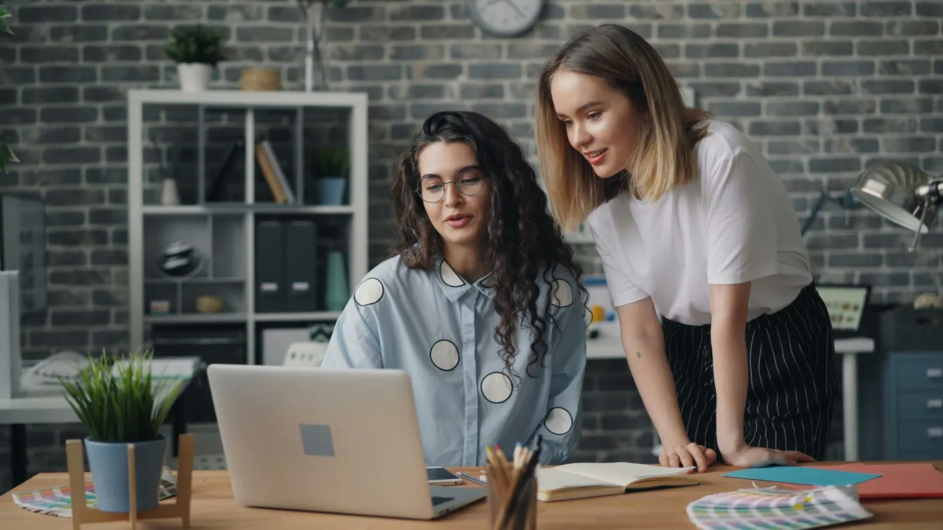 Colleagues looking at a laptop in the office