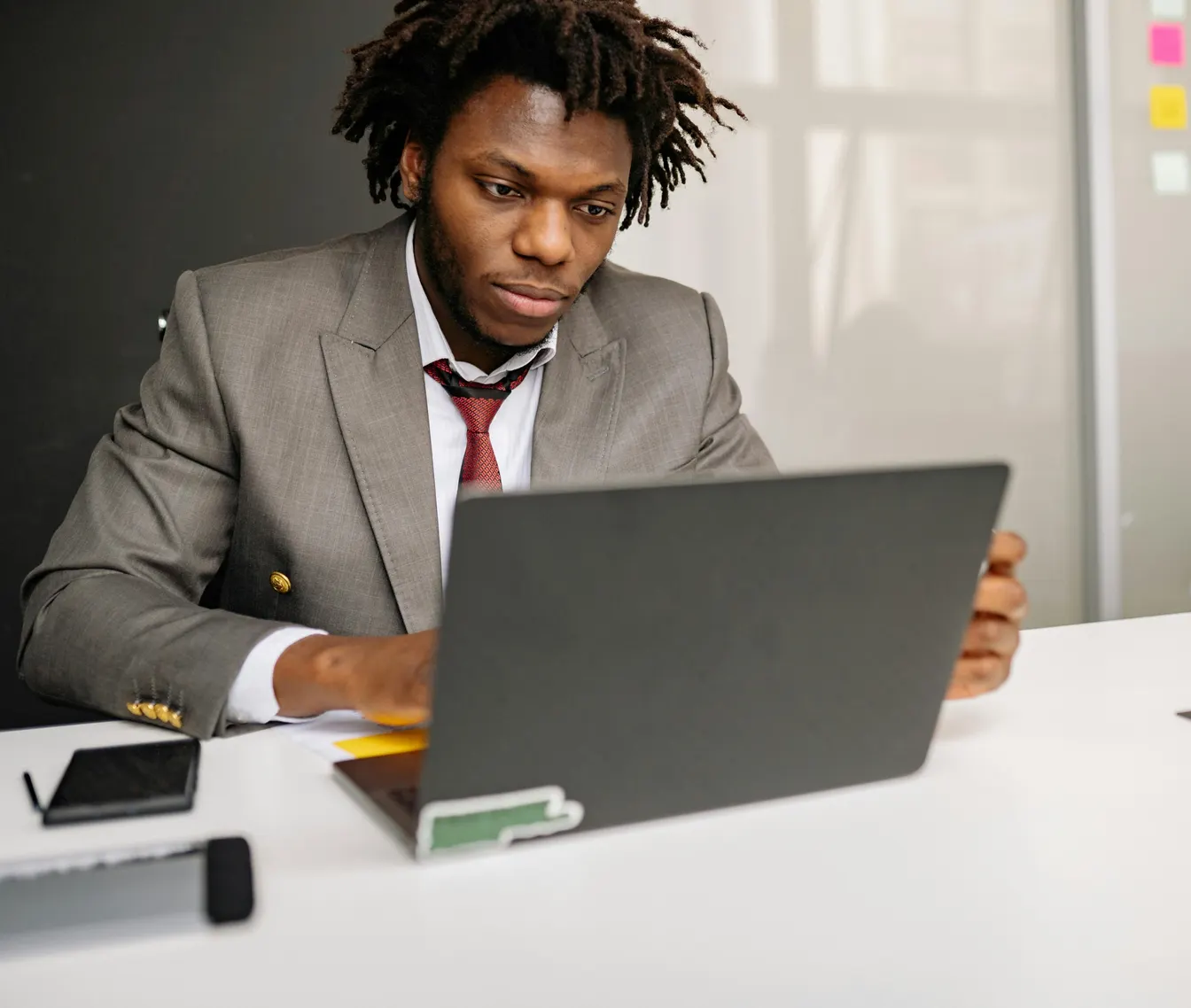 man in business attire using a laptop