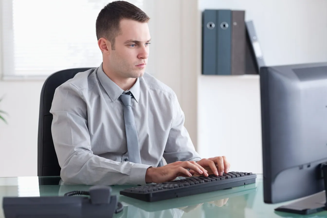 Serious man typing and using a computer
